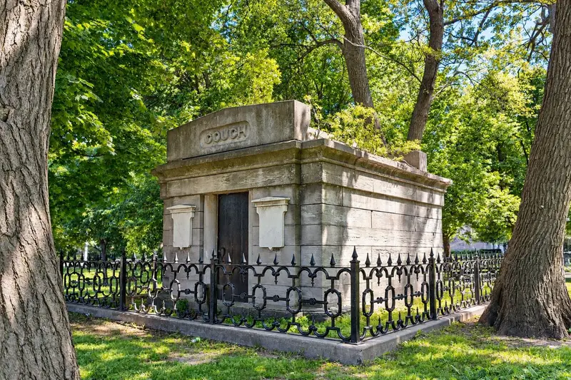 The massive stone exterior of the historic Couch Tomb standing among trees in Lincoln Park, Chicago.