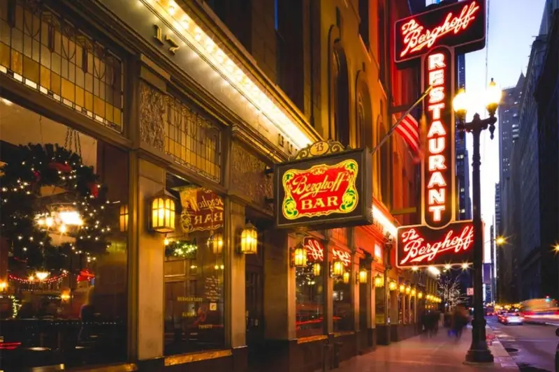 The iconic neon marquee glowing outside The Berghoff restaurant at 17 West Adams Street in the Chicago Loop.